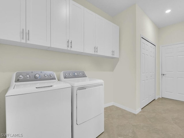 washroom with separate washer and dryer and cabinets