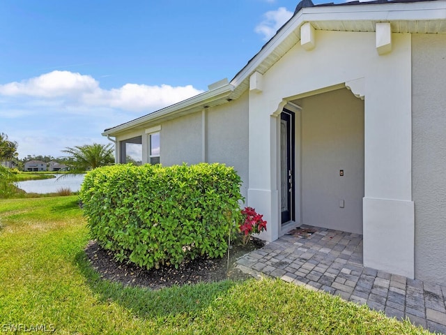 property entrance featuring a yard and a water view