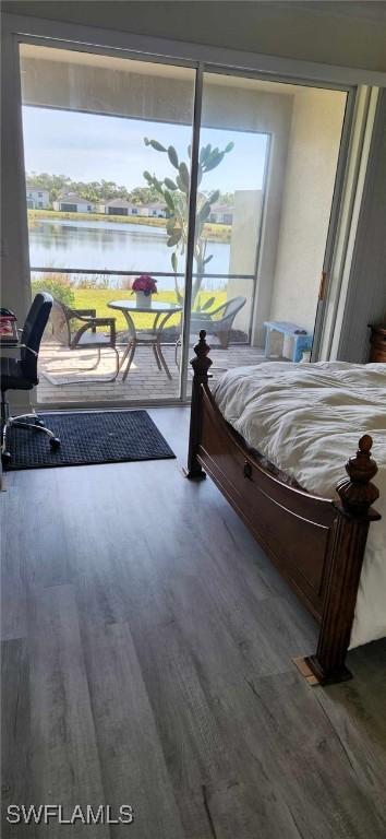 bedroom with wood-type flooring and a water view