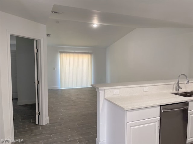 kitchen with stainless steel dishwasher, sink, white cabinets, vaulted ceiling, and hardwood / wood-style flooring