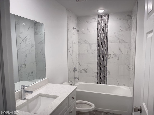 full bathroom featuring toilet, vanity, tiled shower / bath, and tile patterned floors