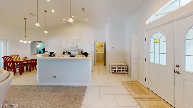 entryway with a notable chandelier, light tile patterned flooring, and high vaulted ceiling