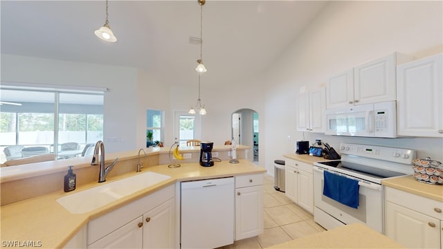 kitchen with hanging light fixtures, white appliances, sink, and high vaulted ceiling