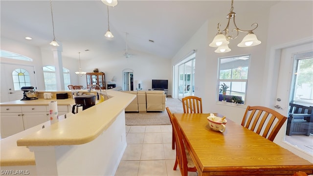 dining area with light tile patterned floors, a chandelier, and high vaulted ceiling