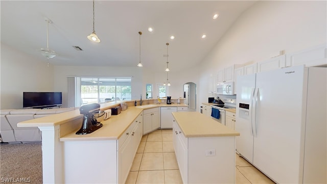 kitchen with white appliances, white cabinetry, a center island, and kitchen peninsula