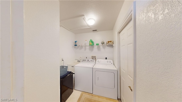 laundry room featuring a textured ceiling and washer and clothes dryer