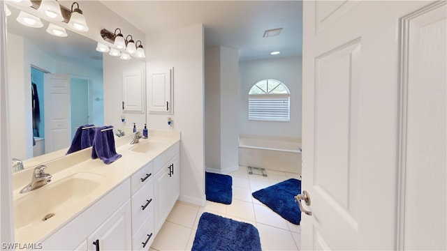 bathroom featuring vanity, tile patterned flooring, and a washtub