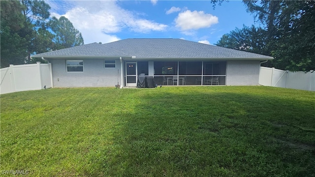 rear view of property featuring a sunroom and a yard