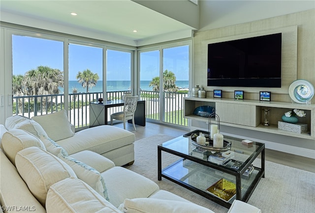 living room with hardwood / wood-style flooring and a water view