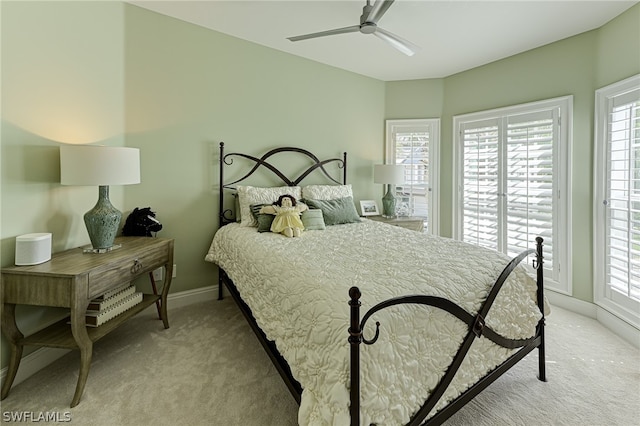 carpeted bedroom with ceiling fan and multiple windows