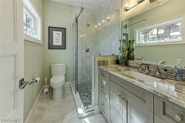 bathroom featuring a healthy amount of sunlight, vanity, tile floors, and toilet