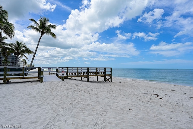 dock area with a beach view and a water view