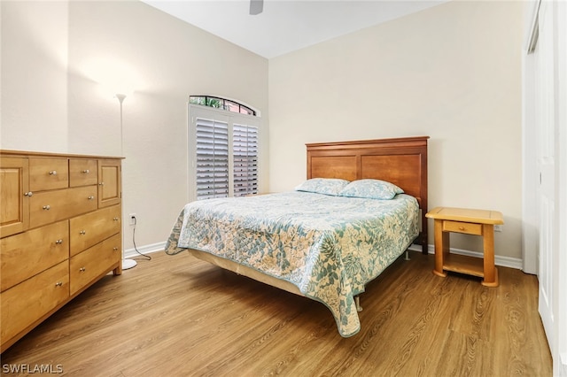 bedroom with light wood-type flooring, vaulted ceiling, and ceiling fan