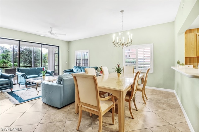 tiled dining area featuring ceiling fan with notable chandelier