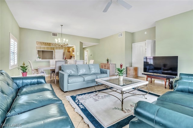 tiled living room with ceiling fan with notable chandelier