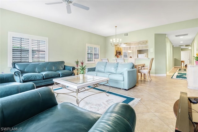 living room with light tile patterned floors and ceiling fan with notable chandelier