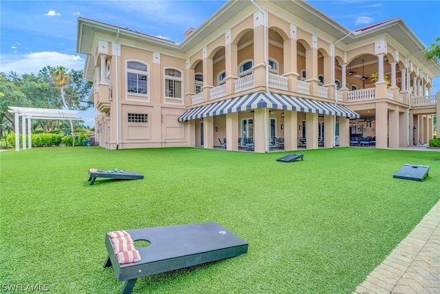 back of property featuring a yard, a balcony, and a pergola