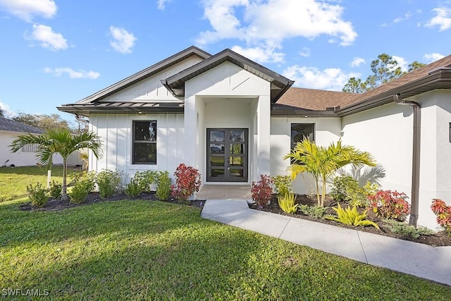 entrance to property featuring a yard and french doors