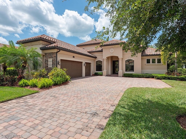 mediterranean / spanish-style house featuring a front lawn and a garage