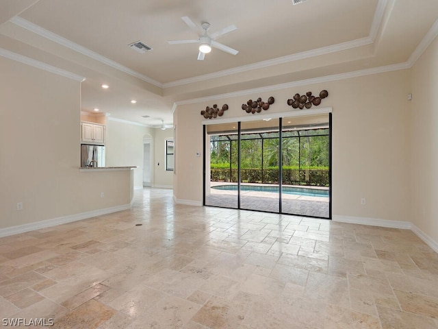 empty room featuring crown molding, a raised ceiling, and ceiling fan