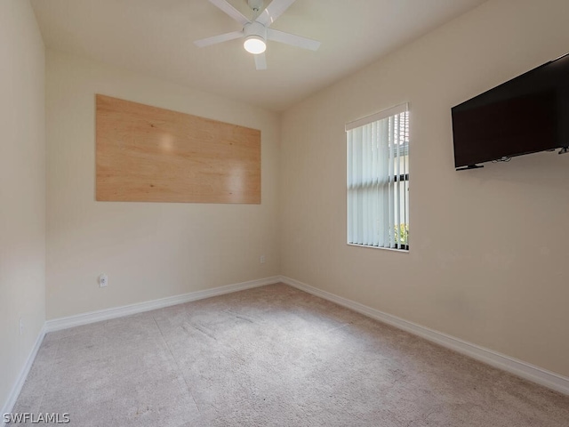 carpeted spare room featuring ceiling fan