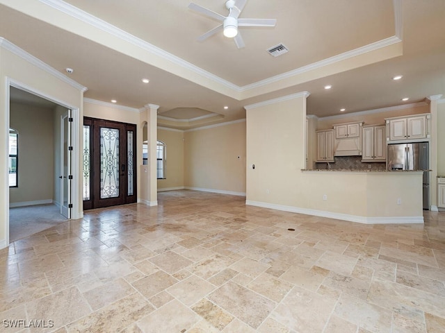 unfurnished living room featuring crown molding, a raised ceiling, and ceiling fan