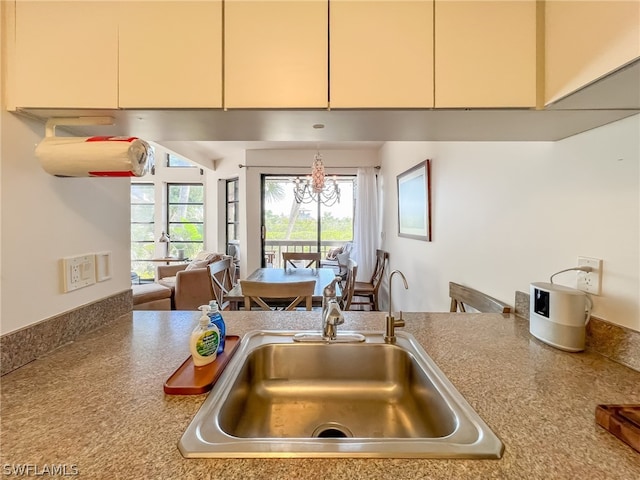 kitchen with sink, a notable chandelier, and decorative light fixtures