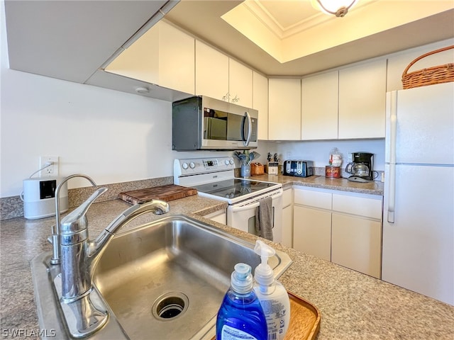 kitchen with white cabinets, sink, white appliances, and a raised ceiling