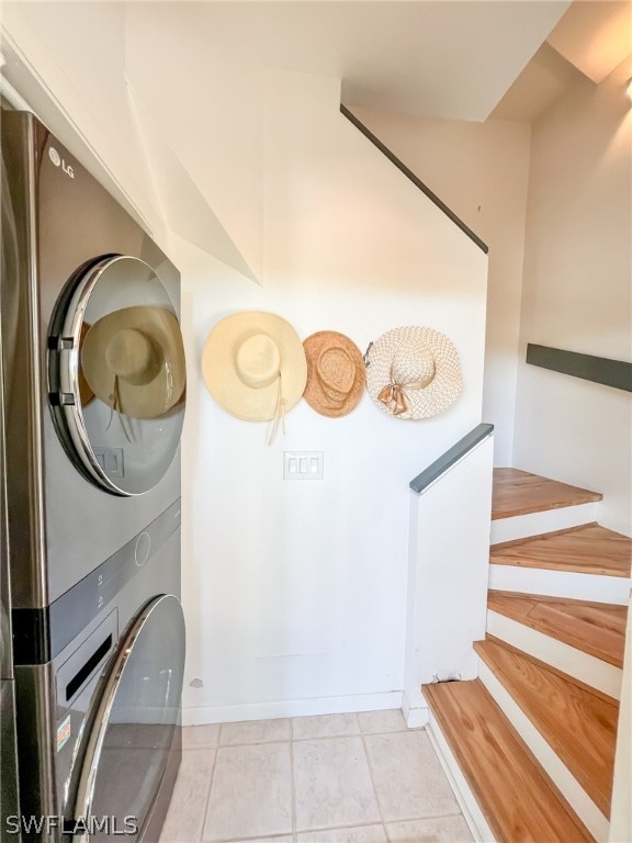 interior space with stacked washer and dryer and light tile floors