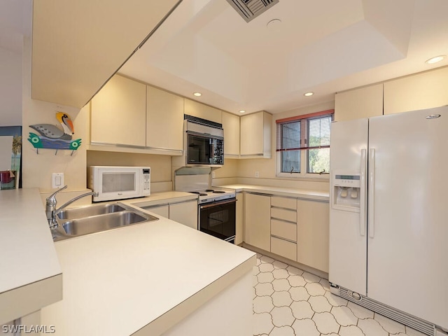 kitchen featuring light tile flooring, white appliances, cream cabinets, and sink