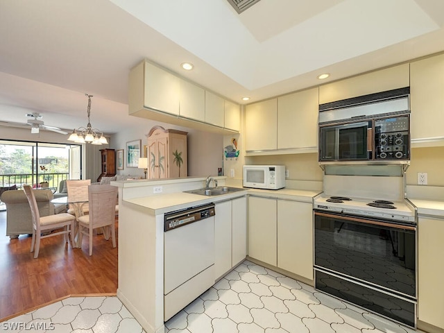 kitchen featuring ceiling fan, light tile floors, sink, white appliances, and kitchen peninsula