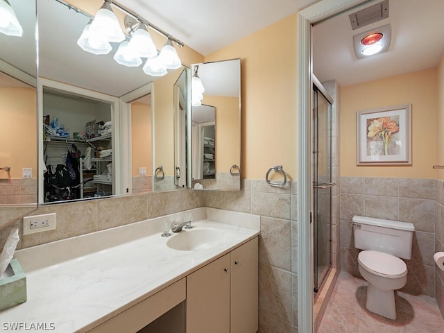 bathroom featuring tile flooring, tile walls, an enclosed shower, toilet, and vanity