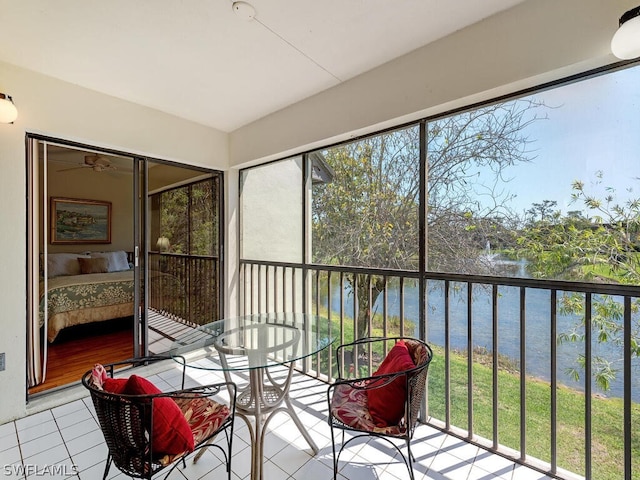 sunroom featuring a water view