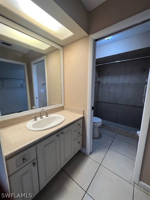 bathroom with toilet, tile flooring, and vanity