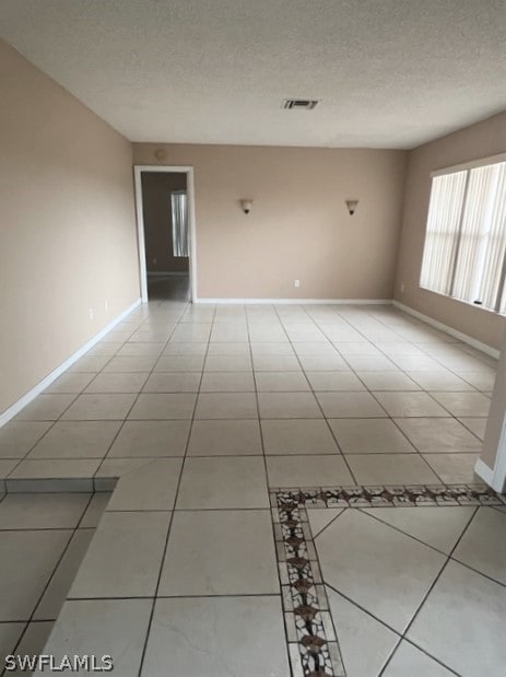 tiled spare room with a textured ceiling