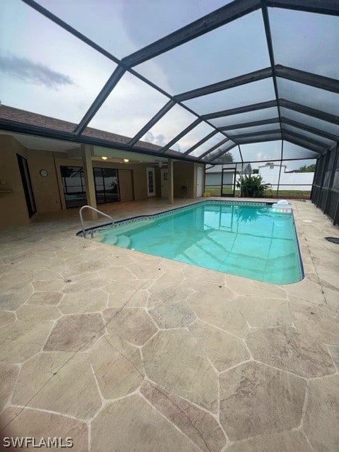 view of pool with a patio and glass enclosure