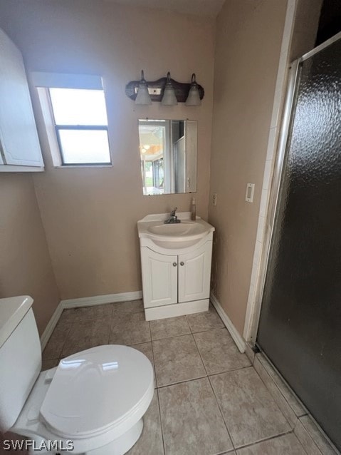 bathroom with oversized vanity, toilet, tile floors, and a shower with shower door