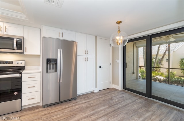 kitchen featuring decorative light fixtures, light hardwood / wood-style floors, appliances with stainless steel finishes, and white cabinetry