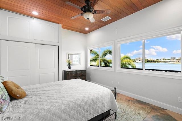 bedroom featuring a closet, ceiling fan, a water view, wood ceiling, and tile floors