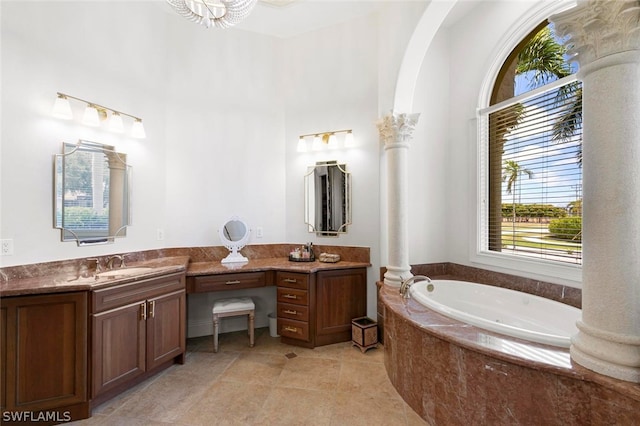 bathroom with double sink vanity, tiled tub, ornate columns, and tile floors