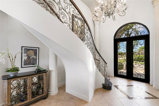 tiled foyer featuring french doors and an inviting chandelier