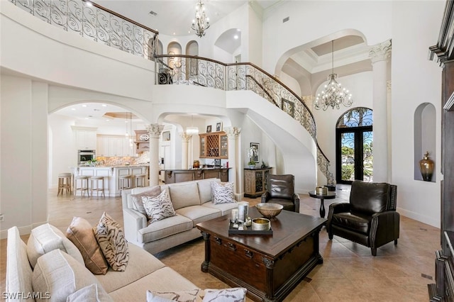 living room with crown molding, light tile flooring, a high ceiling, ornate columns, and a notable chandelier