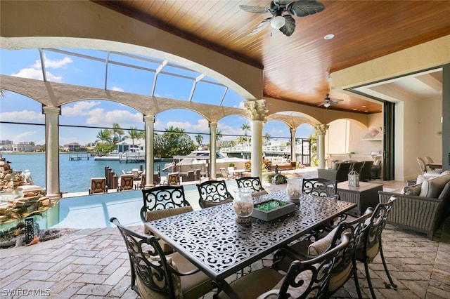 view of patio / terrace with ceiling fan and a water view