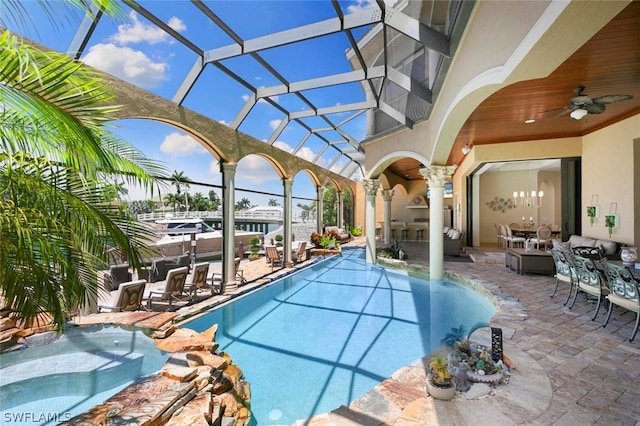 view of pool with a patio, glass enclosure, a hot tub, and ceiling fan