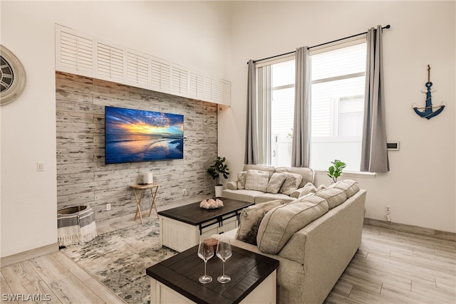 living room with light hardwood / wood-style flooring and wooden walls