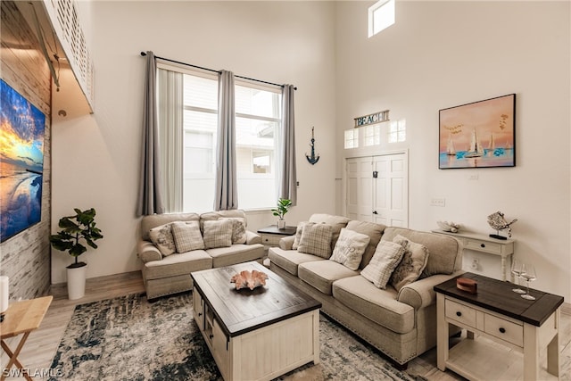 living room with wood-type flooring and a high ceiling