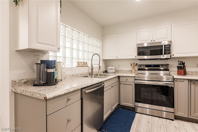 kitchen featuring gray cabinets, appliances with stainless steel finishes, sink, and light wood-type flooring