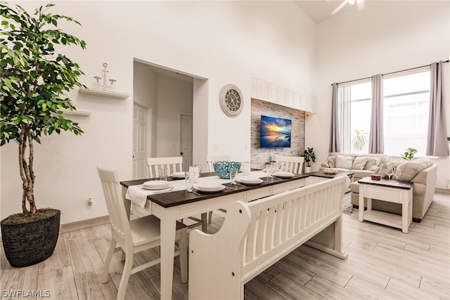 dining space featuring light hardwood / wood-style floors and a high ceiling