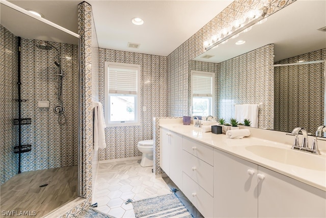 bathroom with large vanity, double sink, walk in shower, toilet, and tile floors