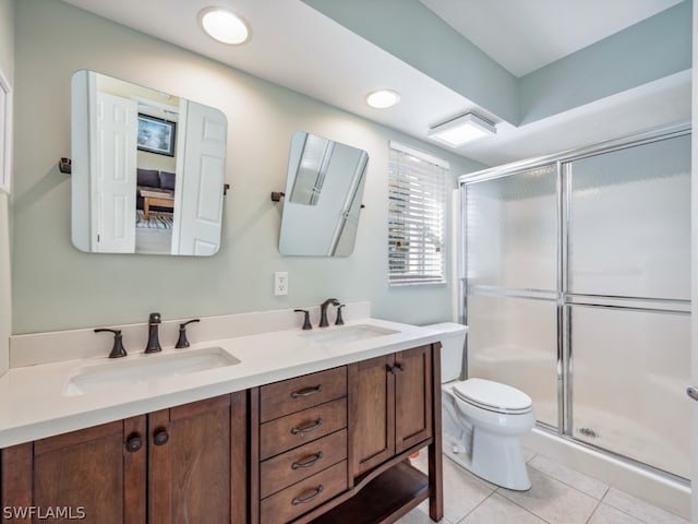 bathroom with an enclosed shower, toilet, tile floors, and double vanity